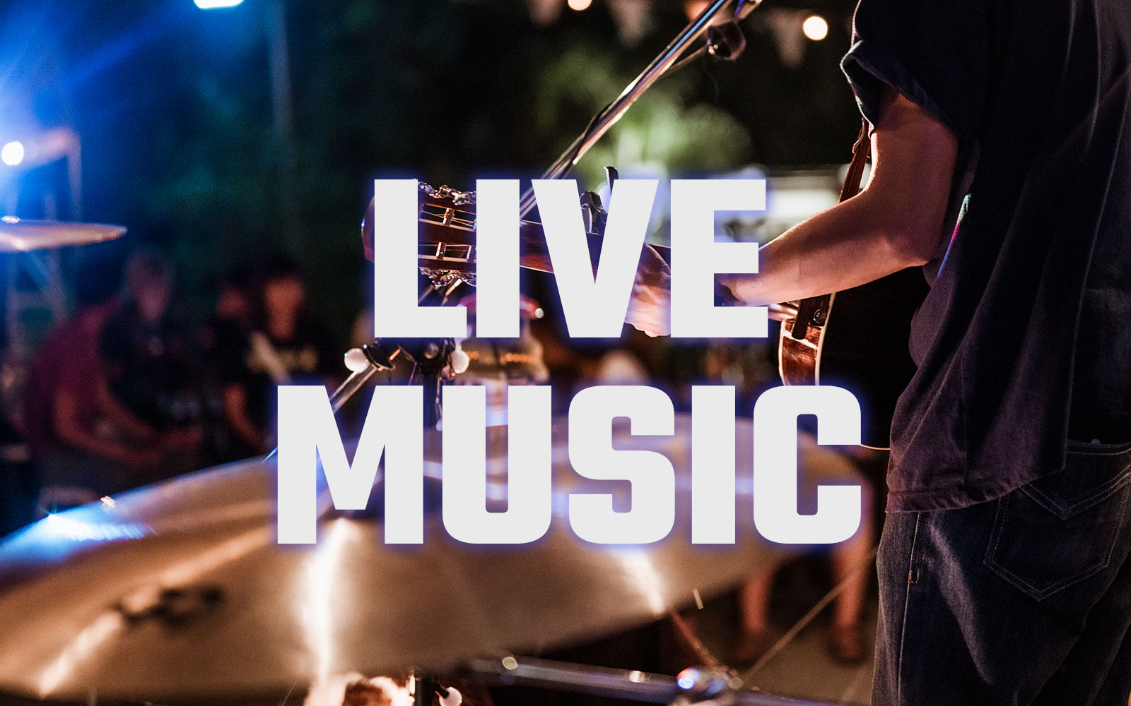 Photo of a guitarist in front of a drummer playing for a crowd.
